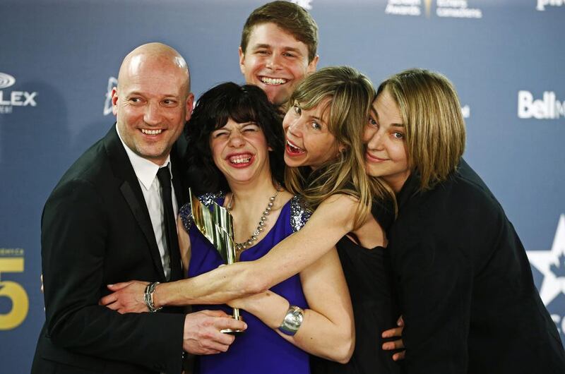 Cast member Gabrielle Marion-Rivard (centre) holds the award for Best Motion Picture for Gabrielle, with fellow cast member Alexandre Landry (top), director Louise Archambault (second from right) and other staff of the movie. Mark Blinch / Reuters