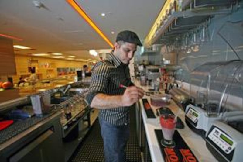 The mixologist Fadi Alia serves a National Sunrise smoothie at Waterlemon juice bar in the Dubai Mall.