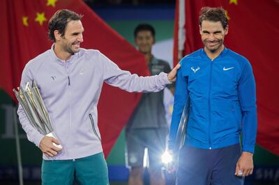 (FILES) This file photo taken on October 15, 2017 shows shows first-placed Roger Federer of Switzerland (L) and second-placed Rafael Nadal of Spain reacting as they hold their trophies after the men's singles final match at the Shanghai Masters tennis tournament in Shanghai.  / AFP PHOTO / Nicolas ASFOURI