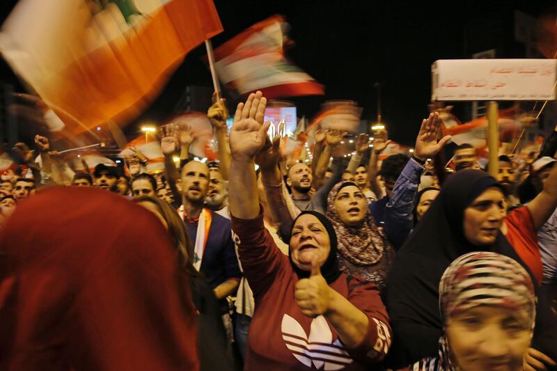 Lebanese protesters wave flags and shout slogans during an anti-government demonstration at al-Nour Square in the northern port city of Tripoli.  AFP