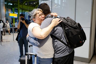 Families embrace as travel rules are eased for vaccinated passengers from the EU and UK. AFP 