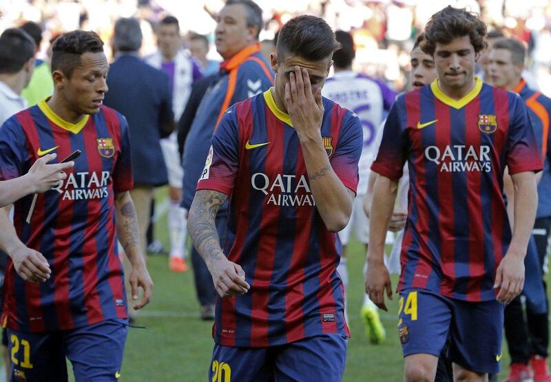 Barcelona's Brazilian defender Adriano, left, Barcelona's forward Cristian Tello and Barcelona's midfielder Sergi Roberto react at the end of the Spanish league football match Valladolid vs FC Barcelona at the Jose Zorilla stadium in Valladolid on March 8, 2014. Valladolid won 1-0. AFP PHOTO/ CESAR MANSO