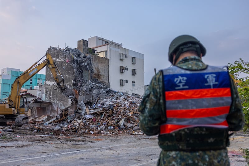 Rescue teams demolish a collapsed building following the earthquake. Getty Images