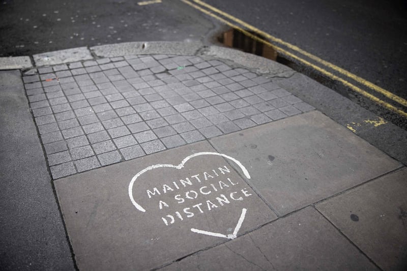 A sign on a pavement advises pedestrians to "Maintain Social Distancing" in central London. AFP
