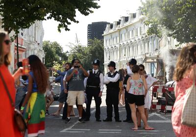 Police secure the area, blocking the road towards the burned out Grenfell Tower apartment block, during the Family Day at the Notting Hill Carnival in west London, Sunday Aug. 27, 2017. The police presence in London has been stepped up because of the holiday weekend and the annual Notting Hill Carnival, a busy weekend street festival that attracts huge crowds. (Yui Mok/PA via AP)