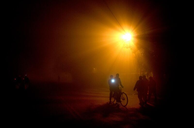 A cyclist uses a torch to see where he is going during  thick fog in Lucknow, India. Rajesh Kumar Singh / AP Photo
