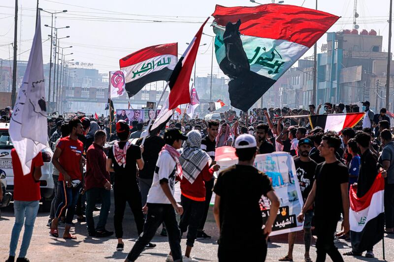 Protesters wave national flags during anti-government protests in Basra. AP