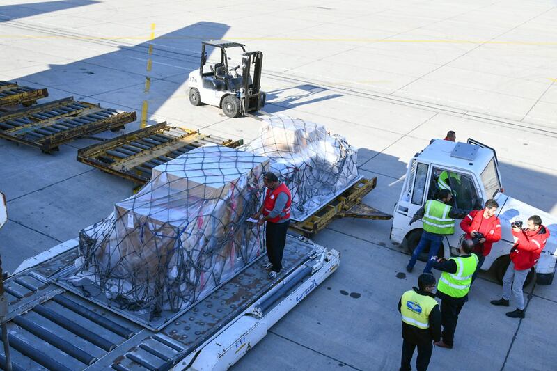 Workers unload boxes of aid from the Norwegian Red Cross, at the Damascus international airport on February 22. Sana / AFP