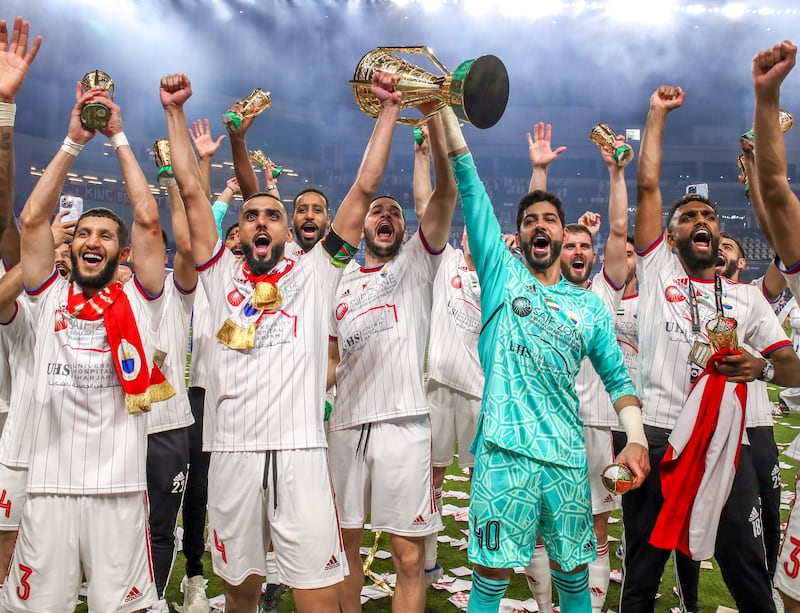 Sharjah players celebrate with the trophy after winning the President’s Cup. Victor Besa / The National
