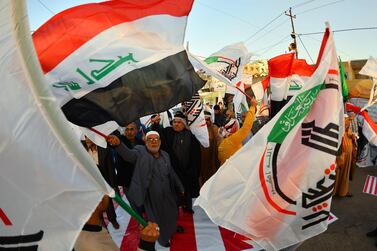 Iraqis wave Hashed Al-shaabi armed network flags on December 30, 2019, during a demonstration to denounce the previous night's attacks by US planes on several bases belonging to the Hezbollah brigades near Al-Qaim, an Iraqi district bordering Syria. US air strikes against a pro-Iran group in Iraq reportedly killed at least 25 fighters, triggering anger in a country caught up in mounting tensions between Tehran and Washington. / AFP / Haidar HAMDANI
