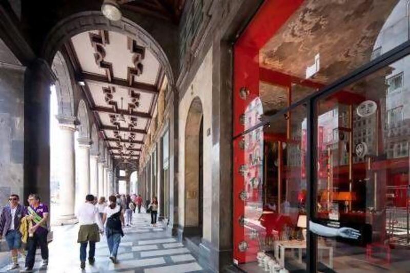 Shoppers stroll along porticoes in Piazza Filippo Meda in Milan, where many of Italy's most prestigious fashion labels can be found. Getty Images