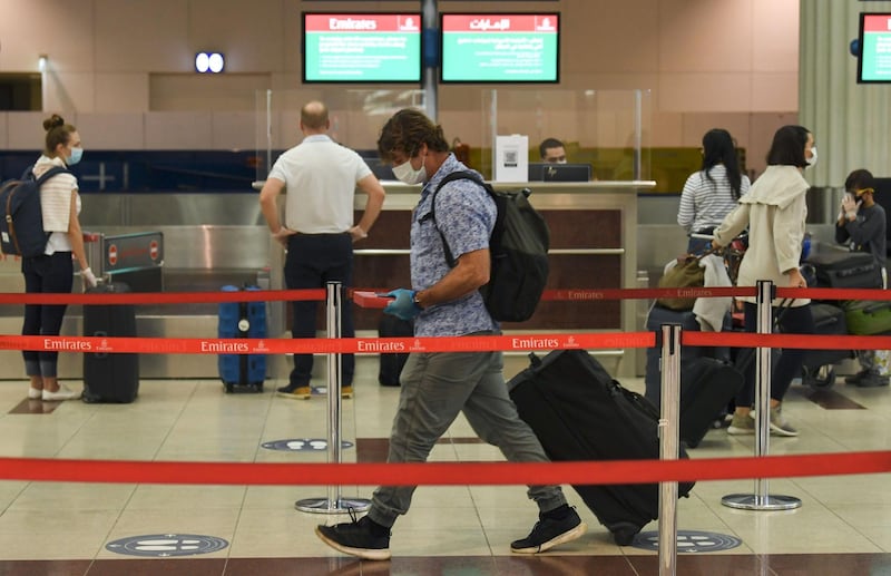 Passengers of an Emirates airlines flight, departing to the Australian city of Sydney, check in at Dubai International Airport on May 22, 2020, after the resumption of scheduled operations by the Emirati carrier, amid the ongoing novel coronavirus pandemic crisis.




  / AFP / Karim SAHIB
