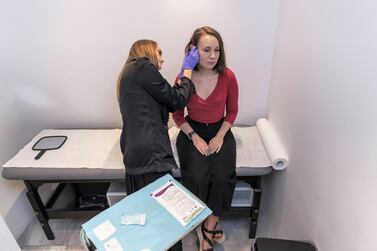 Liz Cookman gets a piercing at the Maria Tash store in The Dubai Mall Antonie Robertson / The National