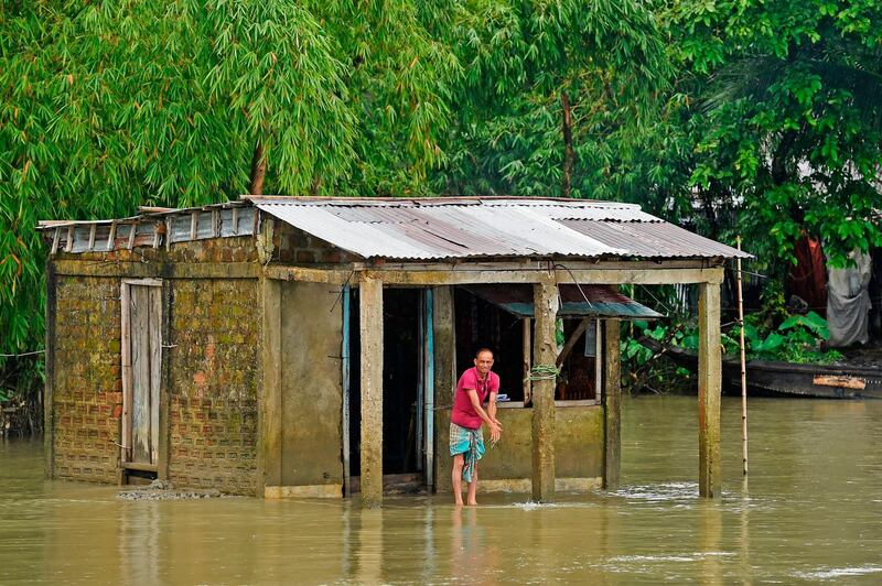 A man stands outside his flooded house in Sunamgong on July 15, 2020. AFP