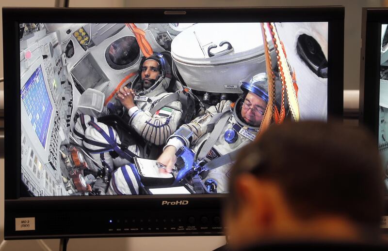 UAE astronaut Hazza Al Mansouri, left, and Roscosmos cosmonaut Oleg Skripochka are seen on screens during their final exams at the Russian cosmonaut training center in Star City outside Moscow, Russia. EPA