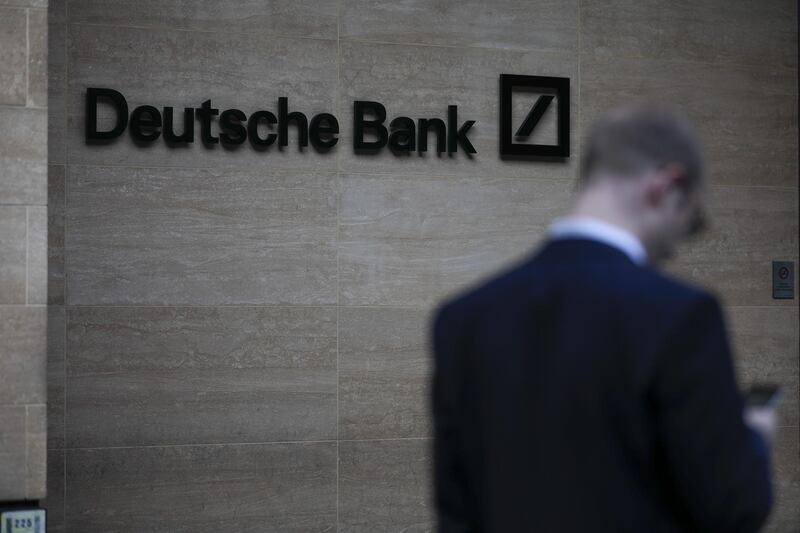 A pedestrian looks at his mobile phone near the offices of Deutsche Bank AG in London, U.K., on Monday, July 8, 2019. Deutsche Bank announced a sweeping turnaround plan that will transform Germany's biggest bank, with Chief Executive Officer Christian Sewing radically shrinking and reshaping its global operations. Photographer: Jason Alden/Bloomberg