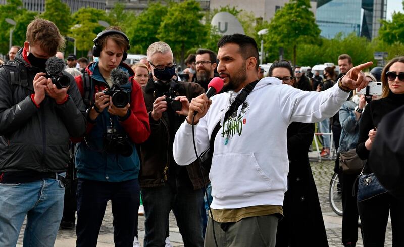 German cookbook author and conspiracy theorist Attila Hildmann (R) speaks during a protest against restrictions implemented in order to limit the spread of the novel coronavirus / COVID-19 pandemic, on May 16, 2020 in Berlin. From anger over lockdown measures to a purported vaccine plan by Bill Gates: a growing wave of demonstrations in Germany by conspiracy theorists, extremists and anti-vaxxers has alarmed even Chancellor Angela Merkel. AFP