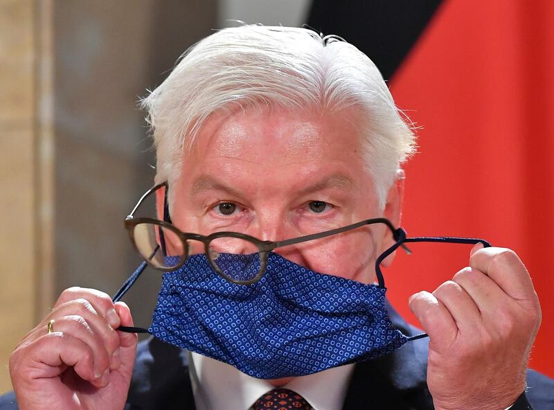German President Frank-Walter Steinmeier struggles with his glasses and face mask as he attends a press conference after visiting the Salzburg Festival in Salzburg, Austria. AP Photo