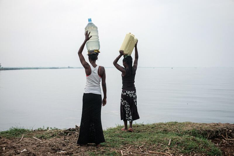 Women hold containers filled with water above their heads after fetching water from the Nile river near the Kisomere village in western Uganda, on January 28, 2020. - When exploitable crude oil deposits were discovered in 2006 in the Lake Albert region, Uganda began to imagine itself as a new oil Eldorado. But 14 years later, the mirage has faded, and it is still waiting to extract its first drops of black gold.
This discovery had raised wild hopes in a country where 21% of the population lives in extreme poverty. The Ugandan government saw the prospect of earning at least $1.5 billion a year and increasing its GDP per capita from $630 to over $1,000. (Photo by Yasuyoshi CHIBA / AFP)