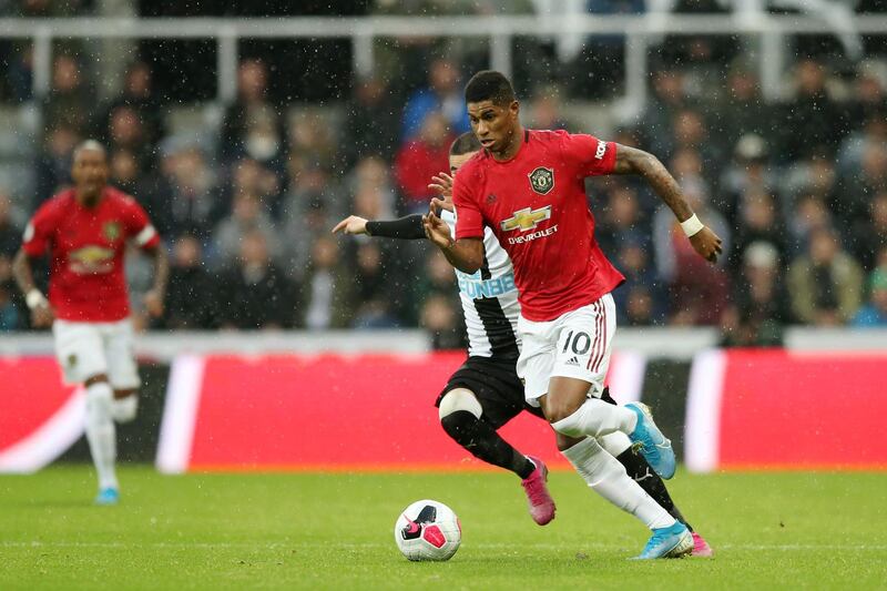 Marcus Rashford runs with the ball with pressure from Miguel Almiron. Getty Images