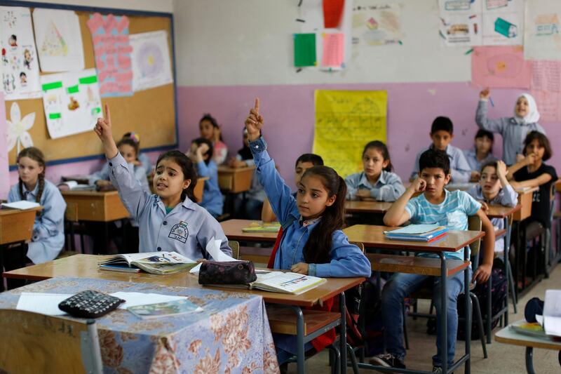 In this Tuesday, May 22, 2018 photo, Sarah, center, a Palestinian refugee from Syria participates in an English lesson at the Jafna Elementary school, run by the U.N. Agency for Palestinian Refugees, UNRWA, in the eastern Bekaa Valley town of Taalabaya, Lebanon. Sarah has come a long way since she arrived in Lebanon after fleeing Syriaâ€™s civil war five years ago, and is now a star student at an elementary school run by UNRWA, which also provides trauma counseling. But those services, and the thousands of children who rely on them, now face an uncertain future, as the U.S. threatens to cut funding. (AP Photo/Hassan Ammar)