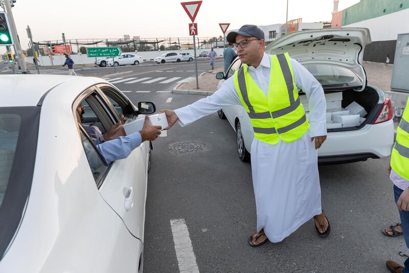 DUBAI, UNITED ARAB EMIRATES. 07 MAY 2019. Iftar meals being distributed to motorists by Marwan Al Hassan (wearing the baseball cap) and his team at the intersection of Al Asayel and 13D Str in Al Quoz 1. (Photo: Antonie Robertson/The National) Journalist: None. Section: National.