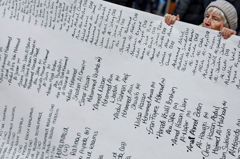 An anti-war demonstrator holds a banner with a list of names of Palestinians killed in the conflict between Israel and Hamas, outside the conference venue in Munich. Reuters