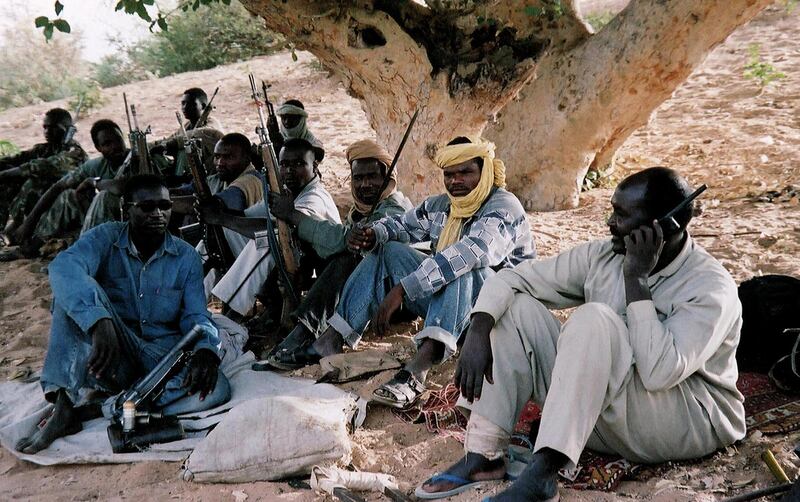 (FILES) -- Picture taken in April 2004 shows members of the southern-based rebel Sudan People's Liberation Army (SPLA), one of them using a satphone, sitting in the forest in Sudan's western region of Darfur. The Sudanese air force bombed 04 Jun 2004 a market in Darfur, a mediator in Chad trying to bring about an end to a conflict which has sparked a serious humanitarian crisis. No casualties were reported in the bombardment. Fighting in the area that has erupted in February 2003 between the Sudanese government and Darfur rebels has claimed at least 10,000 lives and raised the spectre of a devastating humanitarian crisis that could see up to one million die, the UN and international officials have said. The pro-Sudanese government "Janjaweed" militia have been accused of ethnic cleansing against the black population of the Darfur region.            AFP PHOTO/Julie FLINT (Photo by JULIE FLINT / AFP)