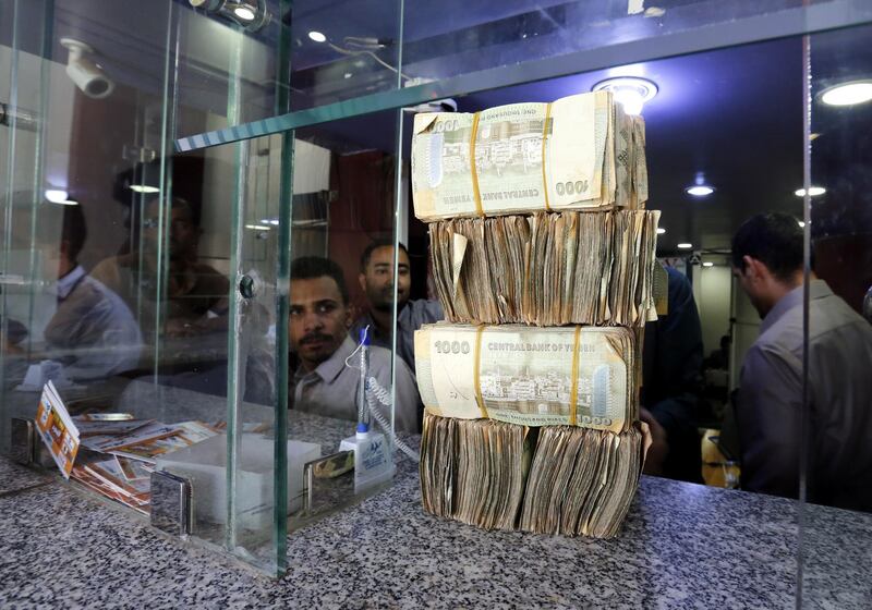 Yemenis exchange currency at an office in Sanaâ.  According to reports, the Rial has lost more than 100 per cent of its value against the US dollar. EPA