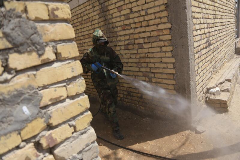 Iraqi civil defence workers sanitise the Tweirij district between Hilla and the city of Karbala against the spread of the coronavirus pandemic. AFP