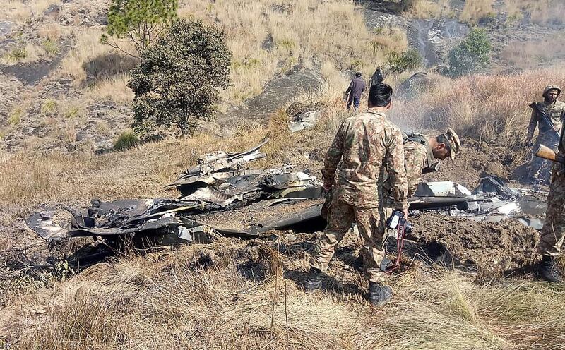 Pakistani soldiers stand next to what Pakistan says is the wreckage of an Indian fighter jet shot down in Pakistan. AFP