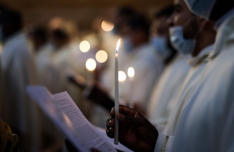 Franciscan friars hold candles as they celebrate the resurrection of Jesus. AFP