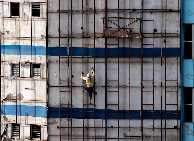 A worker climbs a building to set an advertising billboard in Kathmandu, the capital of Nepal. EPA