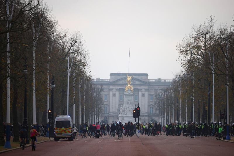 People walk in front of Buckingham Palace as they participate in an anti-lockdown demonstration amid the coronavirus disease (COVID-19) outbreak in London.  Reuters