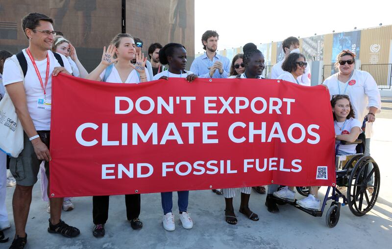 Holding a red banner, activists protest at Cop27.   EPA 
