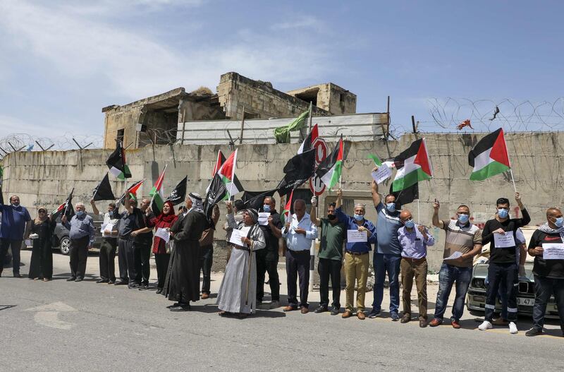 Mask-clad Palestinians demonstrate along the controversial separation barrier at the western entrance of the northern West Bank city of Tulkarem, marking the 72nd anniversary of Nakba. AFP