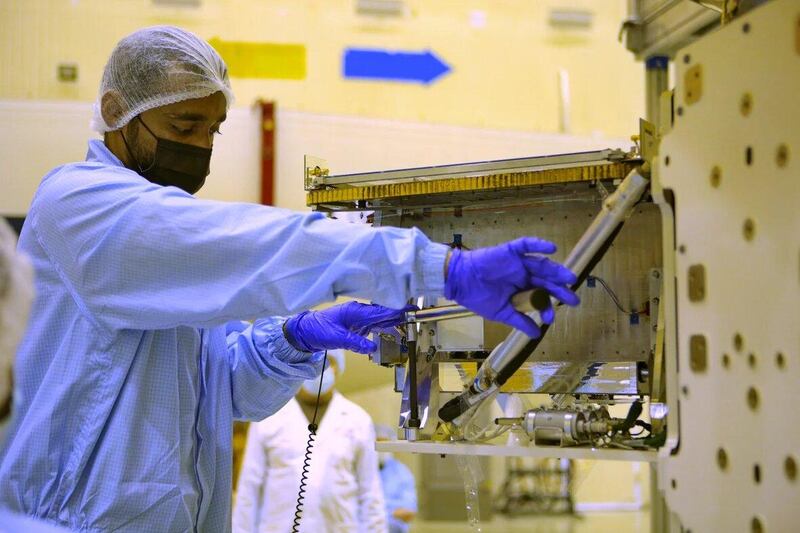 An engineer works on the satellite. Mbrsc