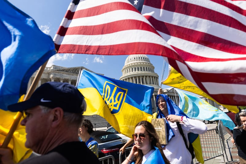 Supporters of Ukraine wave US and Ukrainian flags outside the US Capitol after the vote. EPA
