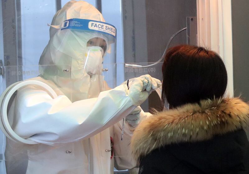 A medical worker takes a sample at an outdoor Covid-19 testing station in Seoul, South Korea. EPA