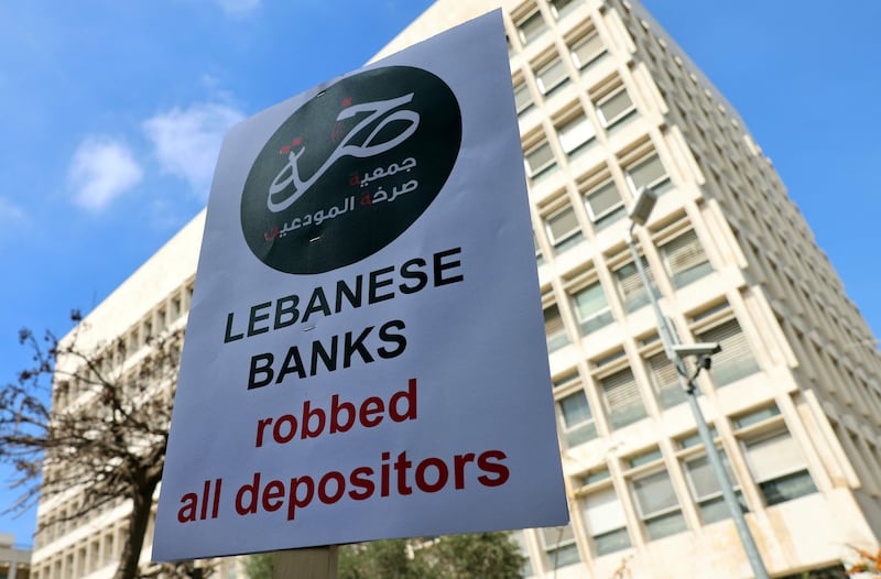 Protesters carry banners outside Lebanon's central bank in Beirut as they demand their savings from Lebanese banks. AFP