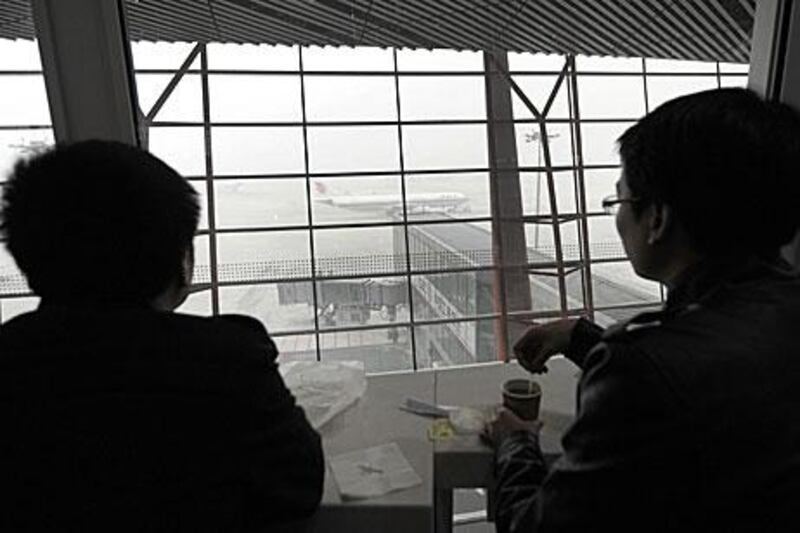 Travellers look at an airplane waiting for take off at Beijing International Airport last week. Hundreds of flights were cancelled due to fog.