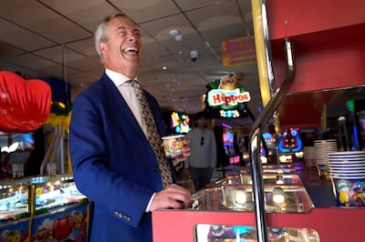 Reform UK party leader Nigel Farage plays in an amusement arcade in Clacton-on-Sea. AP