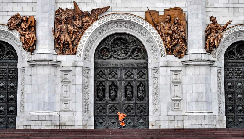 A worker clears the ice from the steps of the Cathedral of Christ the Saviour in Moscow, Russia. AFP