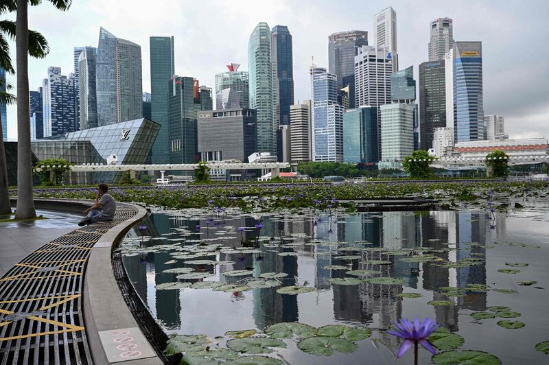 A man sits next the pond at Marina Bay Sands in Singapore on May 14, 2021, ahead of tightening restrictions over concerns of a rise in Covid-19 coronavirus cases. / AFP / Roslan Rahman
