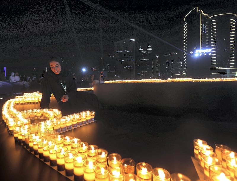 Dubai, March 24, 2018: Emiratii women lights the candles during the Earth Hour Walk at the Marasi promenade in Dubai. Satish Kumar for the National