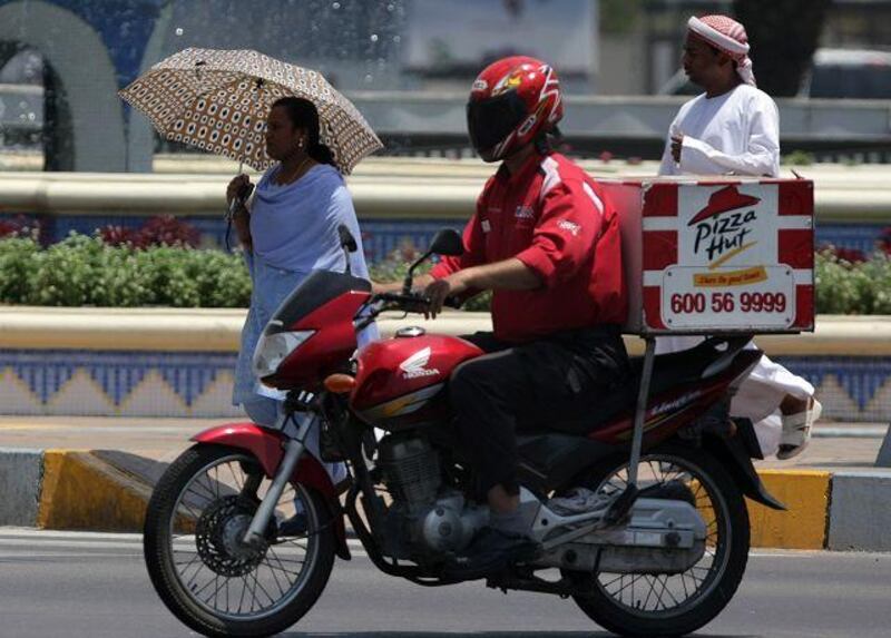 A worker for fast-food franchise Pizza Hut makes a delivery. A survey shows a sizeable number of professionals relying on junk food.