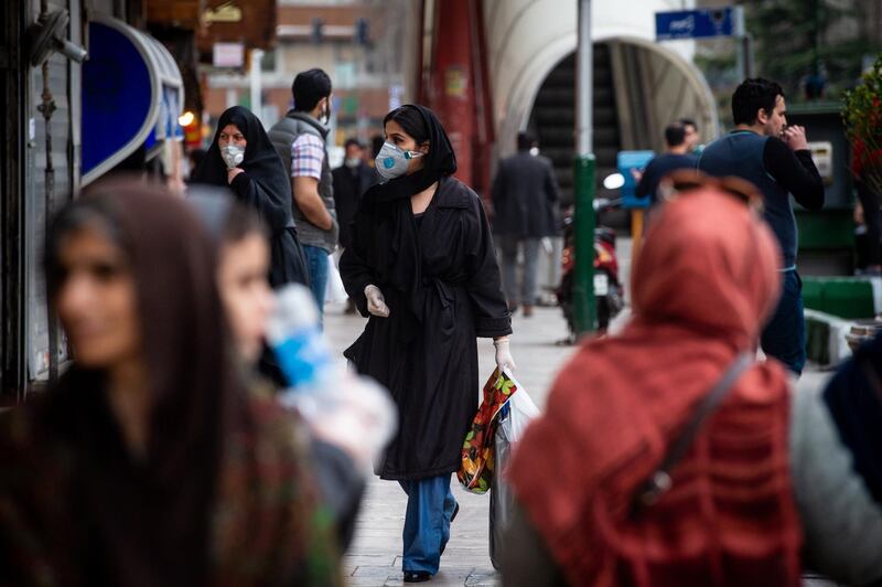 Pedestrians wear protective masks and surgical gloves while walking in central Tehran, Iran,  March 15, 2020. Bloomberg