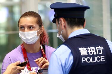 Belarusian sprinter Krystsina Tsimanouskaya talks with police officers at Haneda international airport in Tokyo, Japan August 1, 2021.   REUTERS / Issei Kato