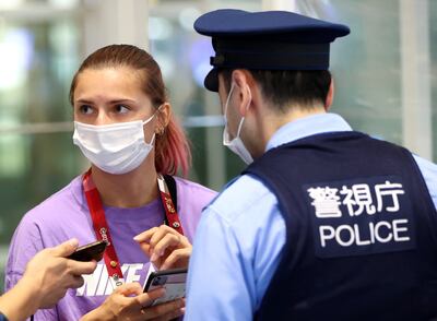 Belarusian sprinter Krystsina Tsimanouskaya talks with police officers at Haneda international airport in Tokyo, Japan.