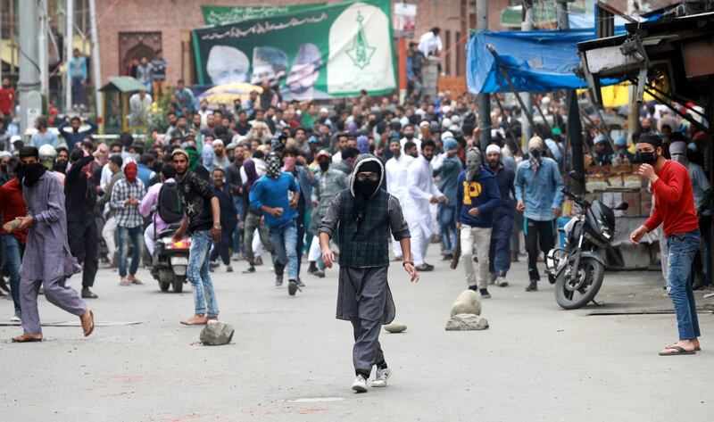 Kashmiri protesters prepare to throw stones at Indian police and paramilitary soldiers during clashes in Srinagar.  Farooq Khan / EPA
